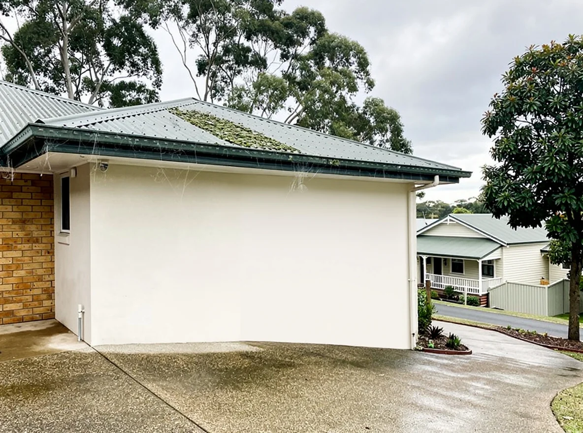 The same The Gap house after soft washing, two-storey render clean and white